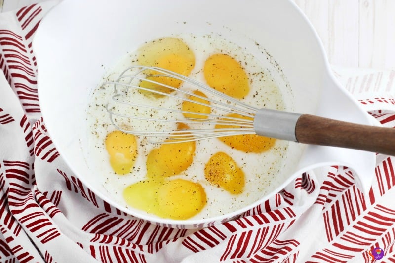 whisking eggs milk salt pepper in bowl