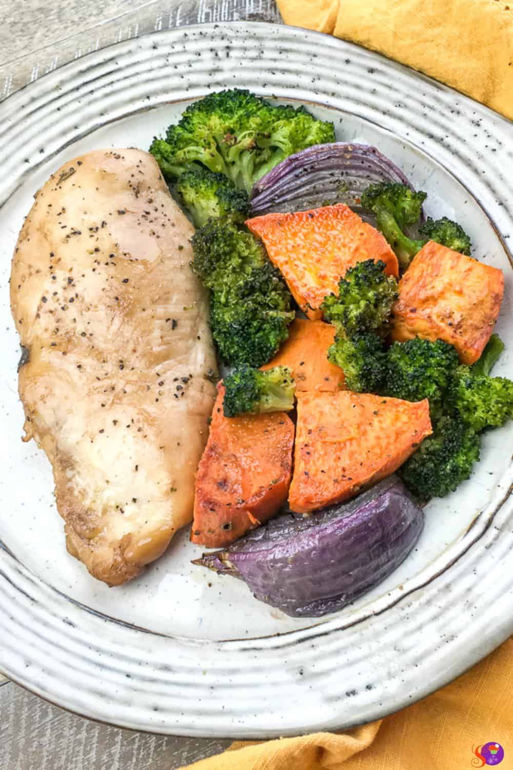 Fresh vegetables and chicken breasts are marinated in a sweet and tangy balsamic glaze in this simple Sheet Pan Balsamic Chicken with Vegetable recipe.