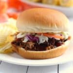 Crock-Pot Texas-Style Pulled Pork on a bun on a white plate