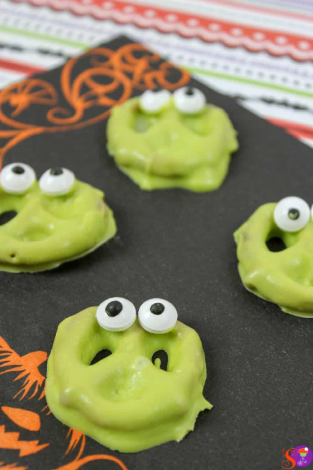 Pretzels are dipped into bright green melted chocolate, then candy eyes are added for a silly monster look in this no-bake Halloween Monster Pretzel recipe  the whole family will enjoy!