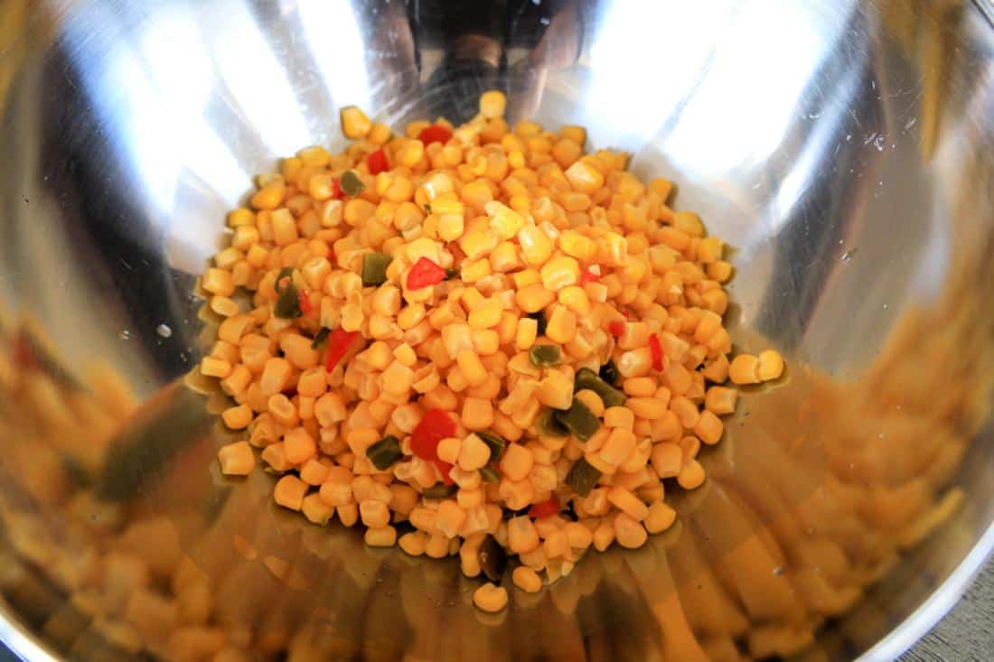 Southwestern Corn Dip: Bowl of corn kernels mixed with diced red and green peppers.