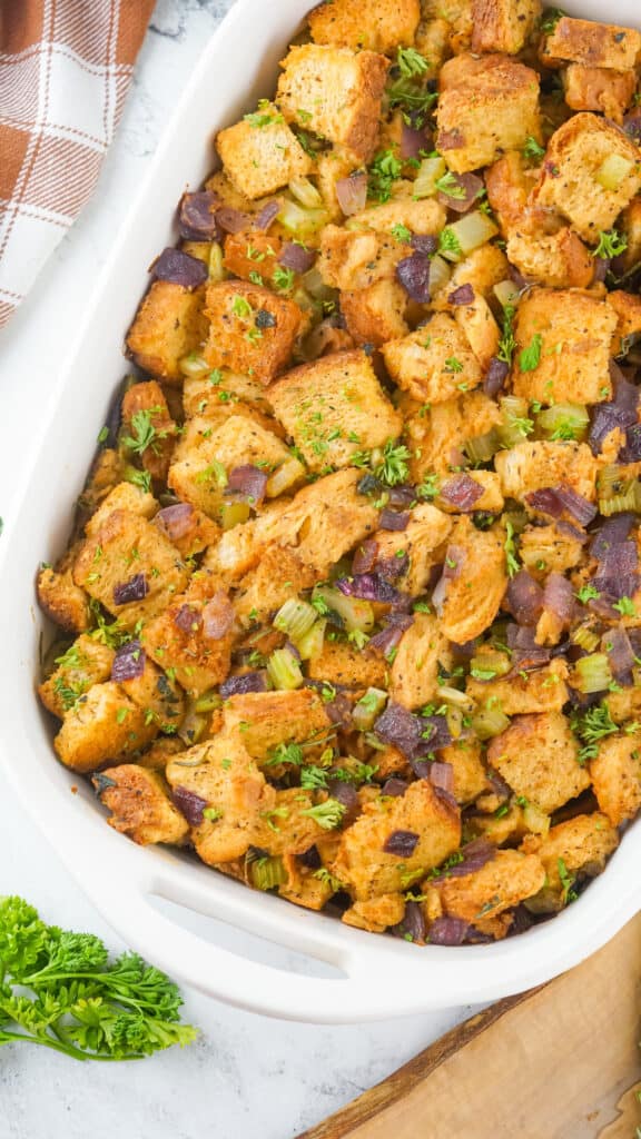 A dish of Traeger smoked stuffing garnished with herbs in a white casserole.