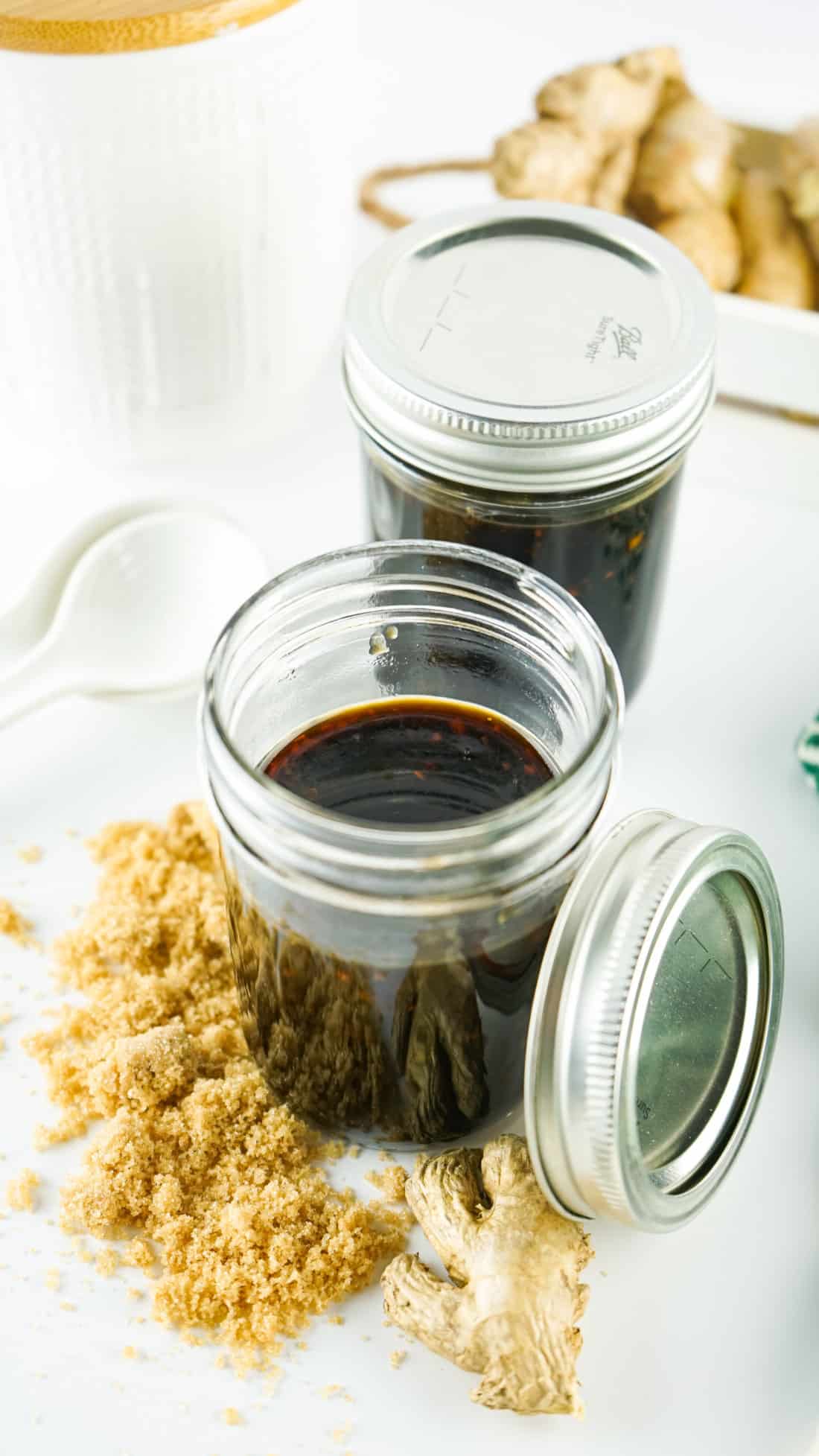 Teriyaki sauce in glass containers with ginger on table