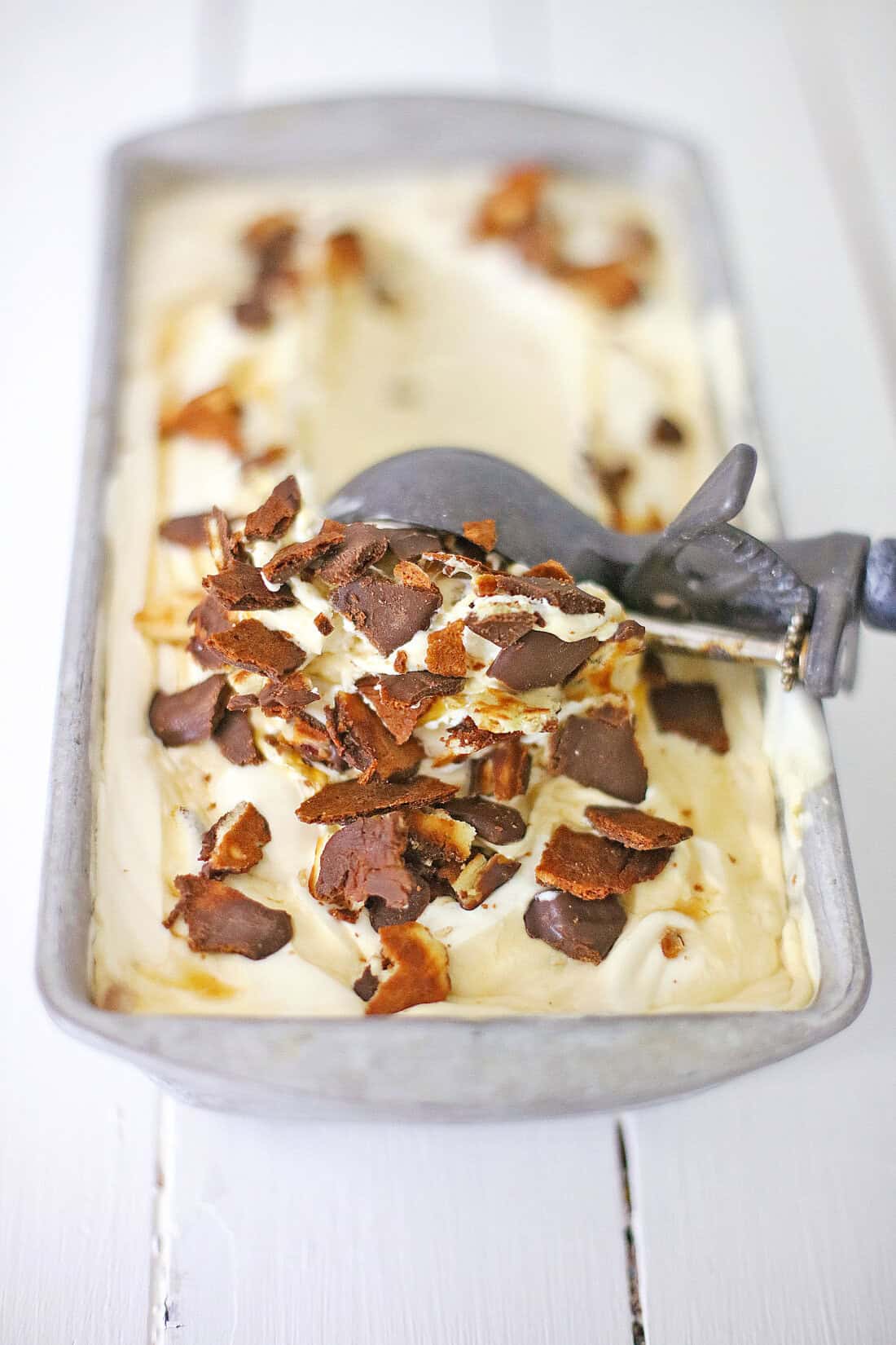 Collage illustrating No Churn Americone Dream Ice Cream being crafted: sweetened condensed milk cascading into cream, caramel swirling in elegantly, and almonds sprinkled on top in separate bowls. A delightful nod to Ben & Jerry’s Copycat No Churn Homemade Americone Dream.