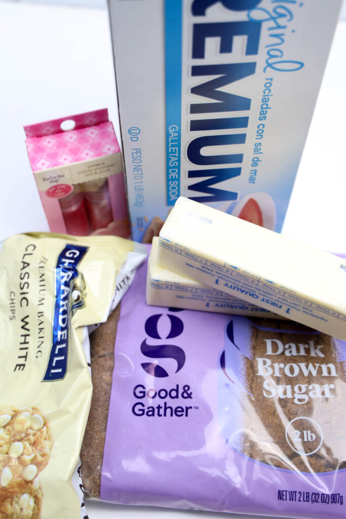 Glitter Valentine's Cracker Candy: A Sweet & Sparkly Treat 3 A collection of baking ingredients perfect for creating Valentine's Cracker Candy, featuring butter sticks, brown sugar, white chocolate chips, vanilla extract, and saltine crackers.