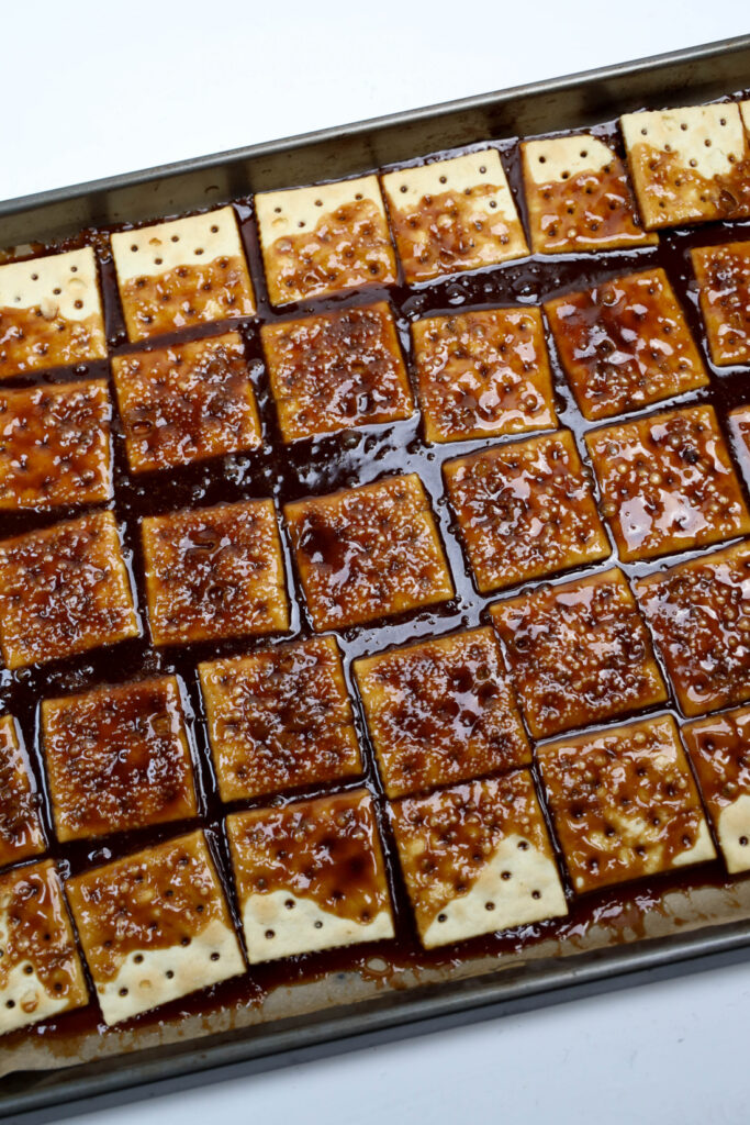 Glitter Valentine's Cracker Candy: A Sweet & Sparkly Treat 6 A tray of Glitter Valentine's Cracker Candy topped with caramelized sauce, arranged in neat rows on a baking sheet.