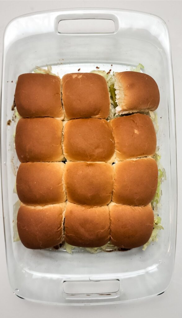 Easy Italian Sliders Recipe 9 A glass baking dish containing nine evenly spaced Italian sliders with golden brown tops. Perfect for anyone looking for an easy Italian sliders recipe that's both delicious and simple to prepare.