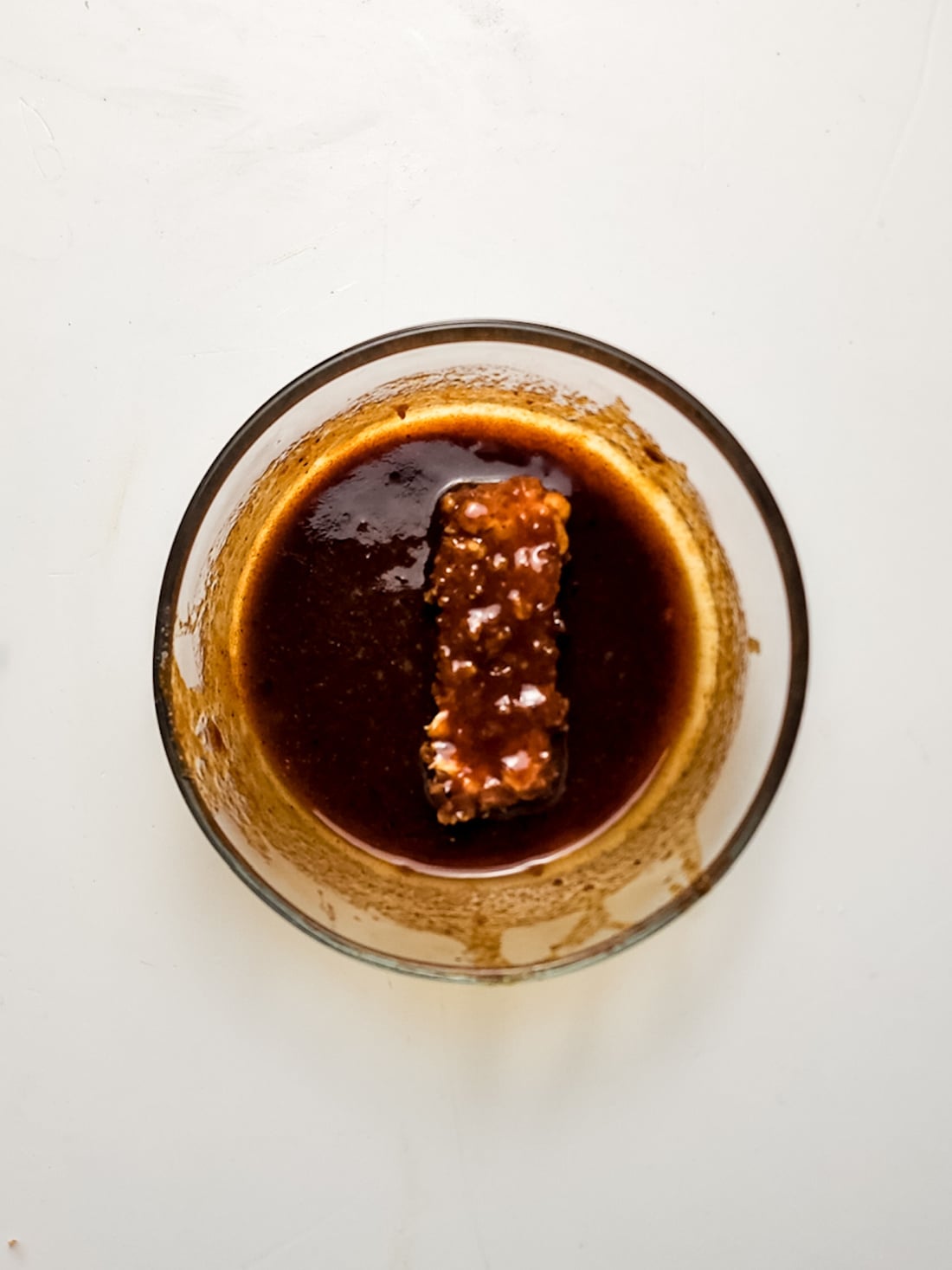 mozzarella stick in a bowl of Nashville hot glaze.