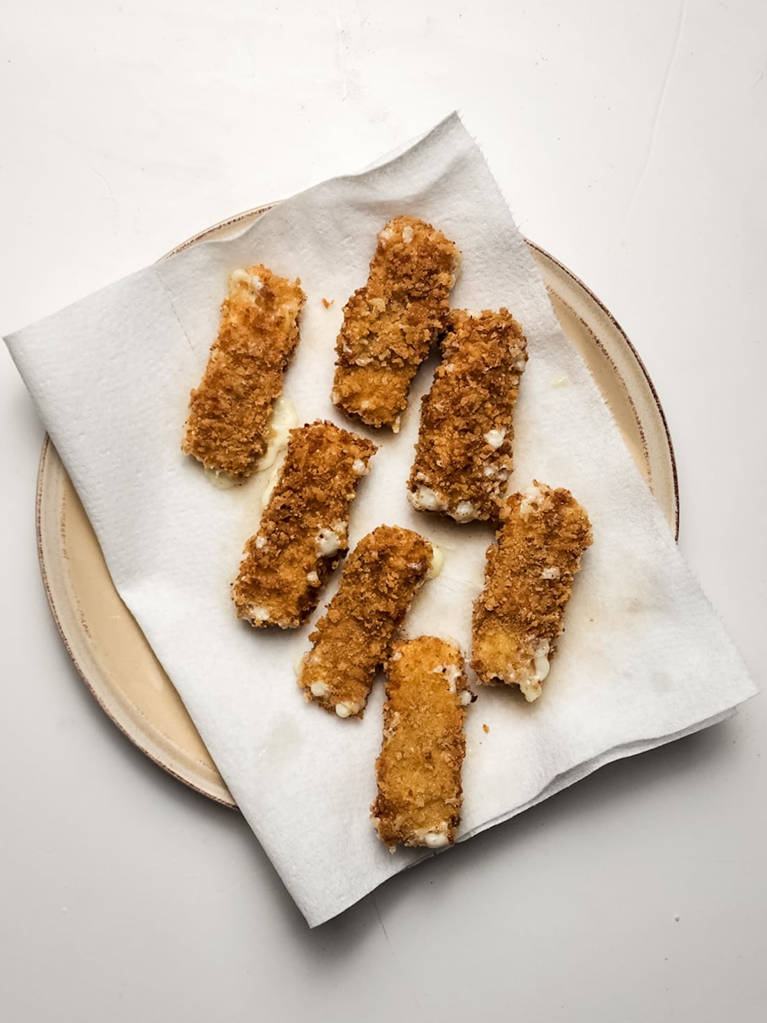 mozzarella sticks resting on paper towels.