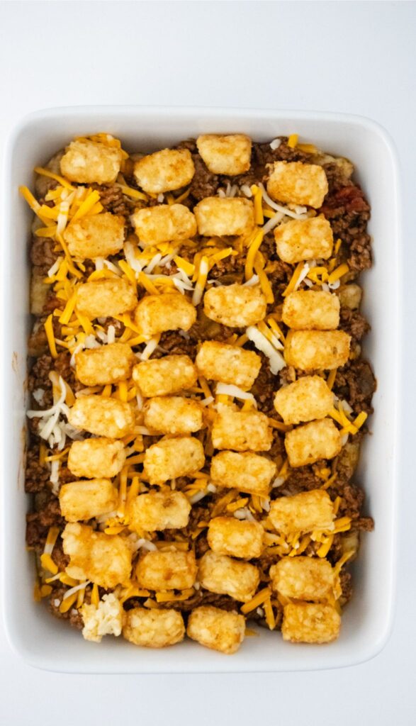 Enjoy a Tasty Taco Tot Casserole featuring ground meat, shredded cheese, and the rest of the tots on top tots on.