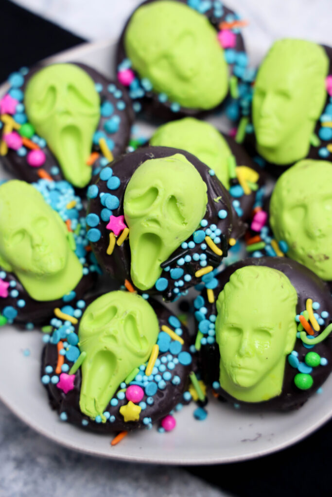 A plate of Summerween Slasher Oreos decorated with bright green faces and colorful sprinkles captures the playful spirit of Summerween.