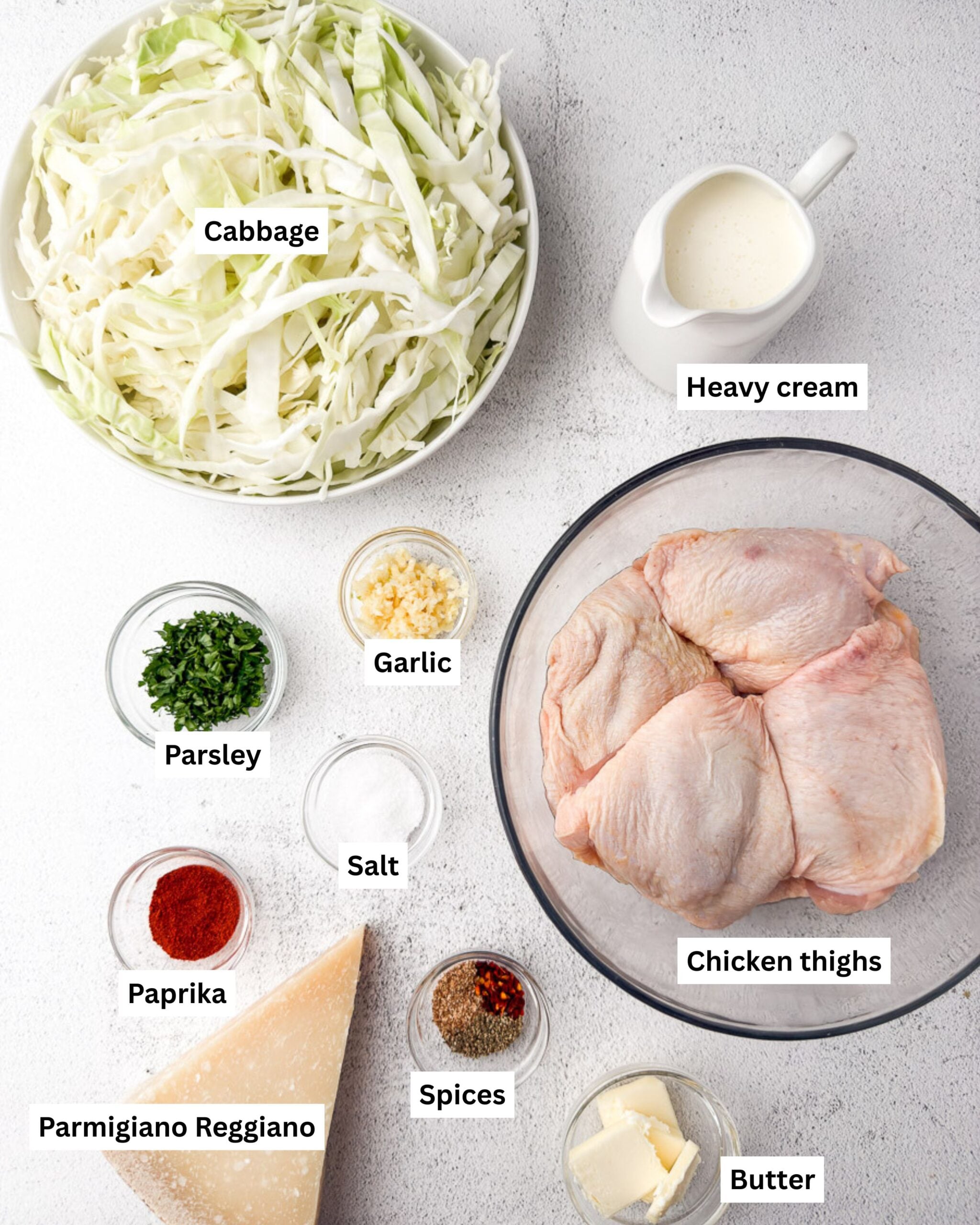 creamy cabbage alfredo ingredients - cabbage, heavy cream, garlic, parsley, paprika, salt, chicken thighs, parmesan,spices, butter
