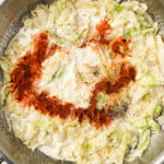 creamy cabbage alfredo sauce in pan with spices on top