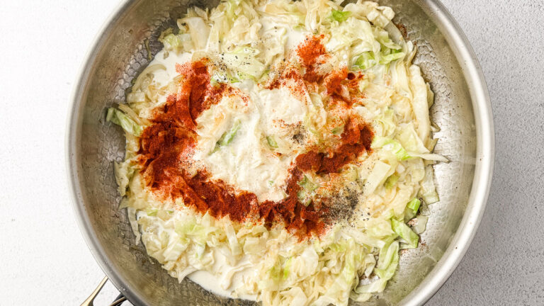 Creamy Cabbage Alfredo with Crispy Chicken Thighs (A Low-Carb Comfort Dinner) 17 creamy cabbage alfredo sauce in pan with spices on top