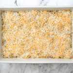 ground beef and rice casserole with shredded cheese on top