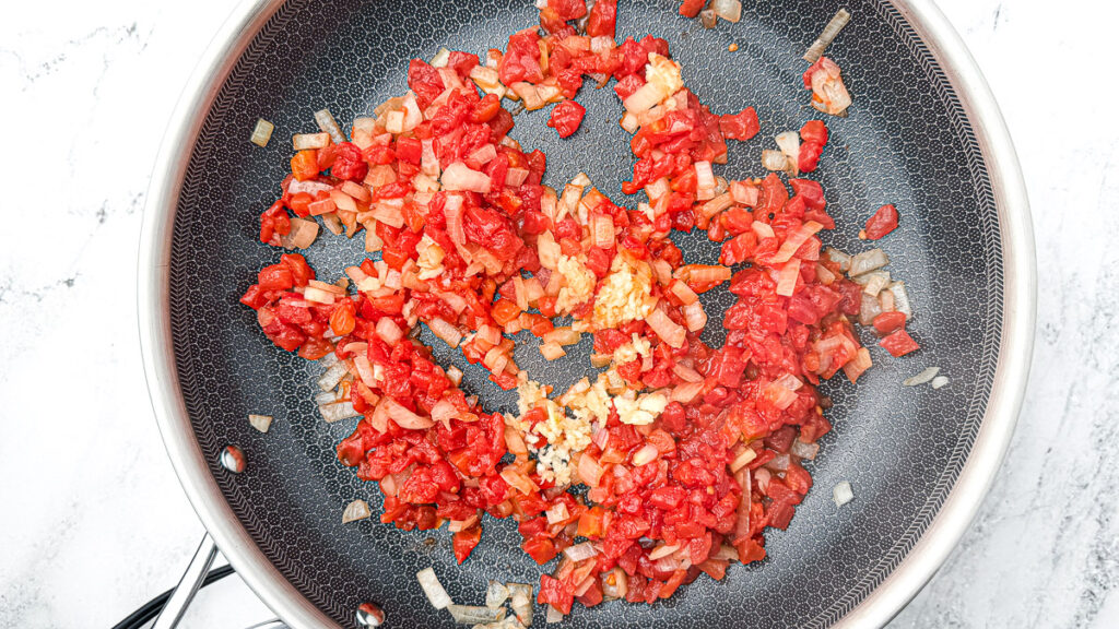 diced onion, tomatoes and garlic sauteeing in a pan