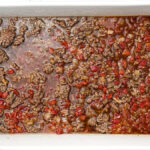 cooked ground beef, onion, tomatoes, garlic and uncooked rice, beef broth in an oven proof pan