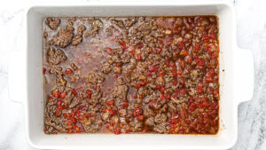 cooked ground beef, onion, tomatoes, garlic and uncooked rice, beef broth in an oven proof pan