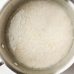 pan with water, oil, salt and rice boiling