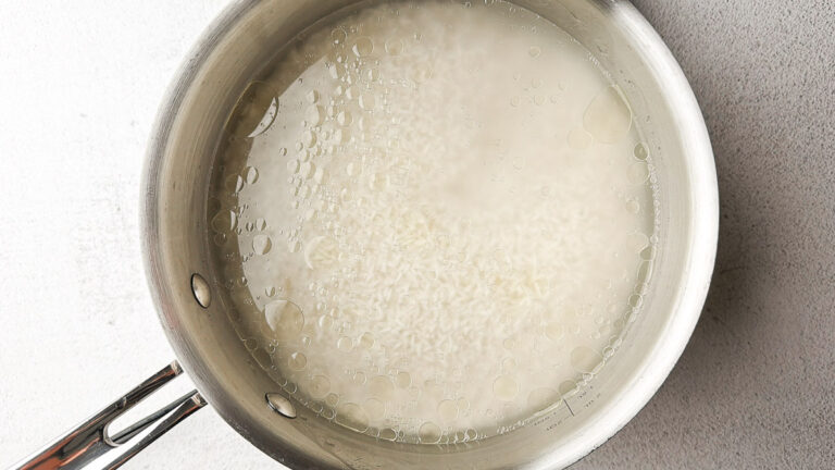 pan with water, oil, salt and rice boiling