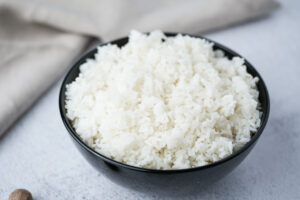 How To Cook Rice recipe plate with cooked rice in black bowl