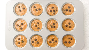 Healthy Almond Butter Banana Chocolate Chip Muffins in muffin pan with chocolate chips on top