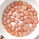 creamy cabbage and kielbasa skillet ingredients - sliced kielbasa in skillet