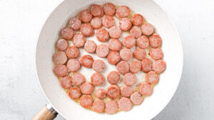 creamy cabbage and kielbasa skillet ingredients - sliced kielbasa in skillet
