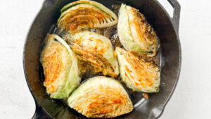 cabbage wedges with miso honey sauce on top in cast iron skillet