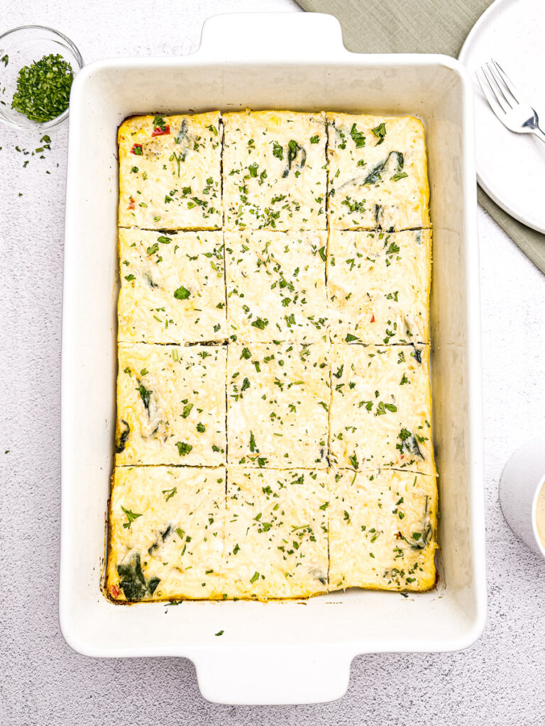 Easy Sausage and Egg Breakfast Casserole (No Bread!) 1 A 9x13 dish of Sausage Egg Breakfast Casserole No Bread sliced into fluffy squares.