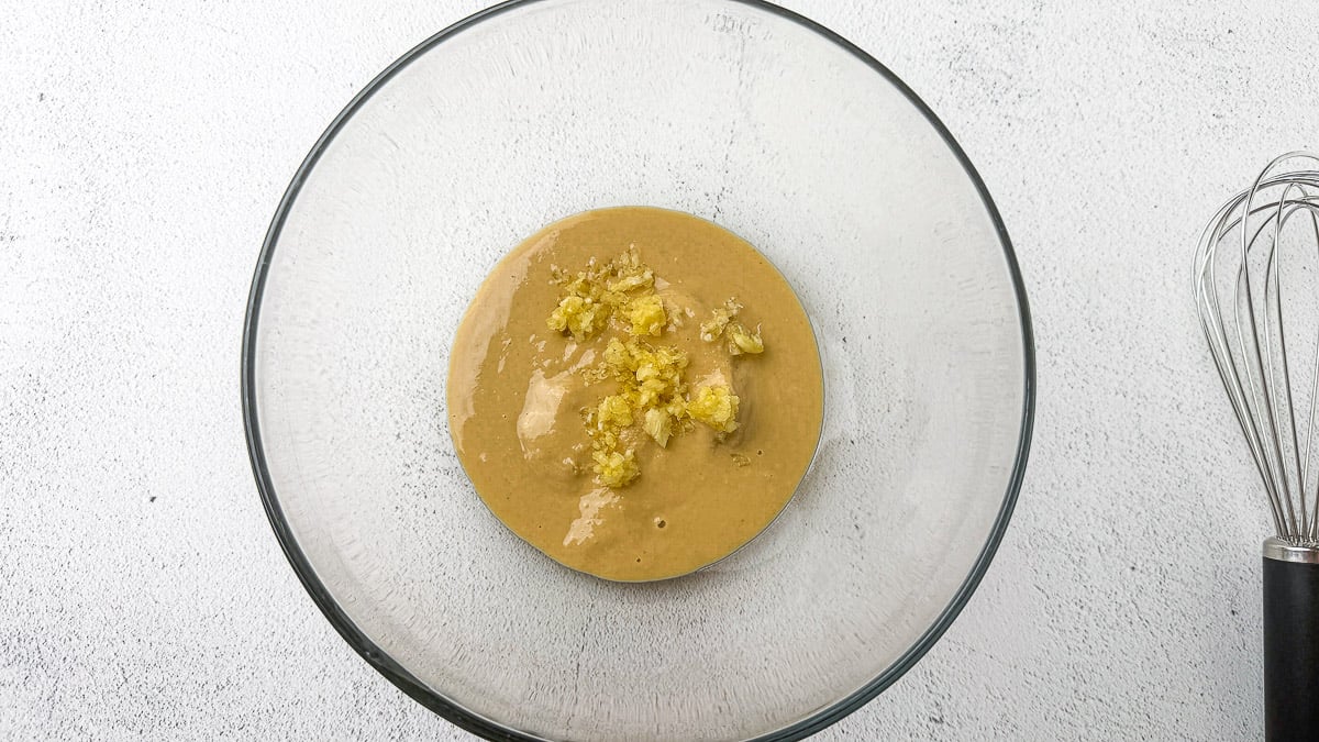 Tahini and garlic in glass mixing bowl