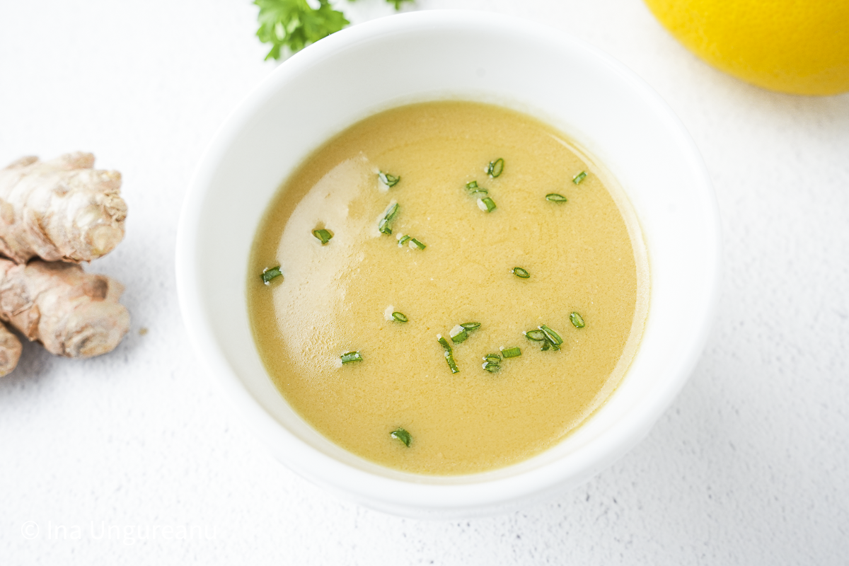 Ginger miso dressing in bowl next to ginger and lemon