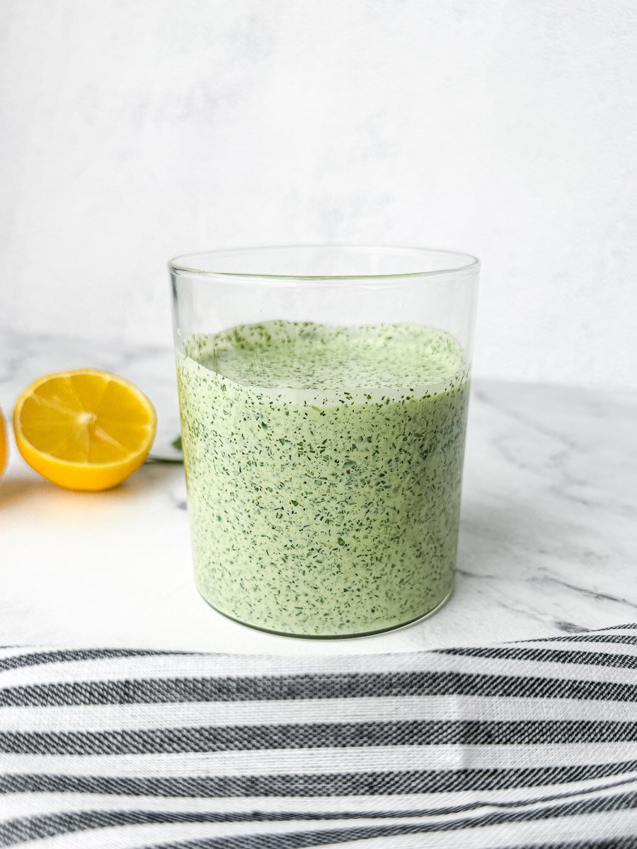 Green goddess dressing in glass jar on table