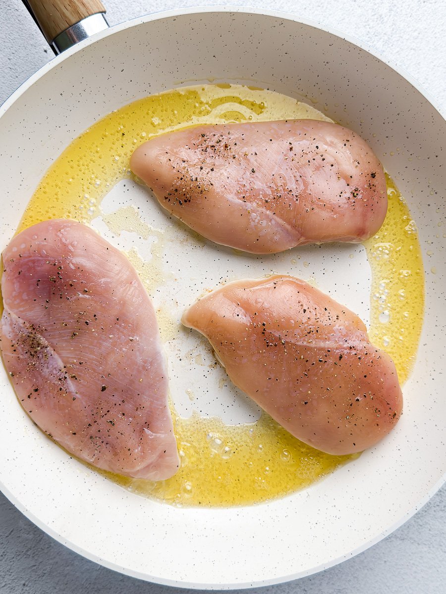 Chicken breast seared in ghee in white pan
