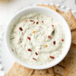 Roasted garlic cottage cheese dip in white dip bowl with crackers