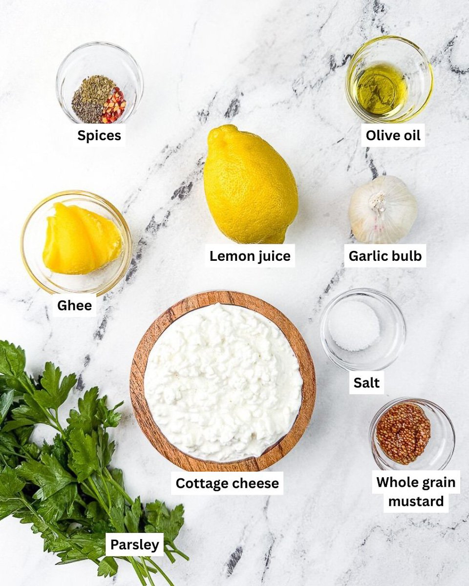 ingredients displayed on countertop: spices, olive oil, lemon juice, ghee, garlic bulb, salt, cottage cheese, parsley, whole grain mustard
