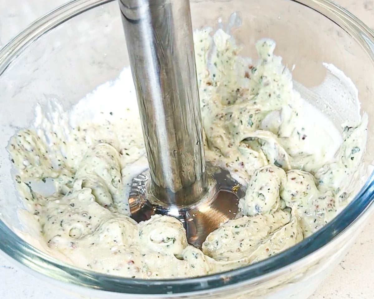 immersion blender in glass mixing bowl with cottage cheese and ingredients