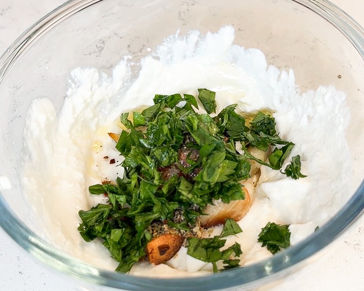 ingredients added to blended cottage cheese in glass mixing bowl