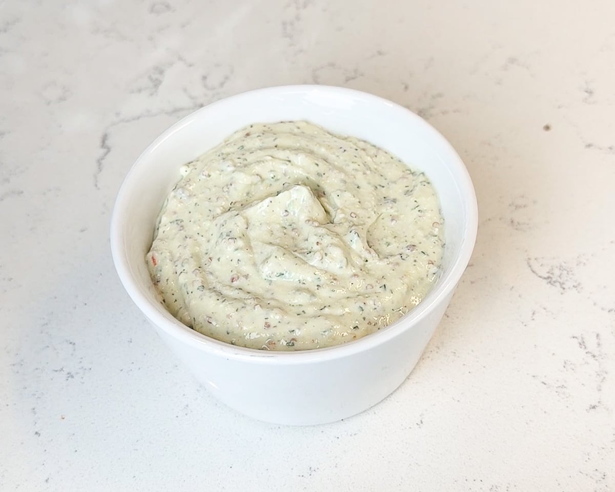 roasted garlic cottage cheese dip in white dip bowl on countertop
