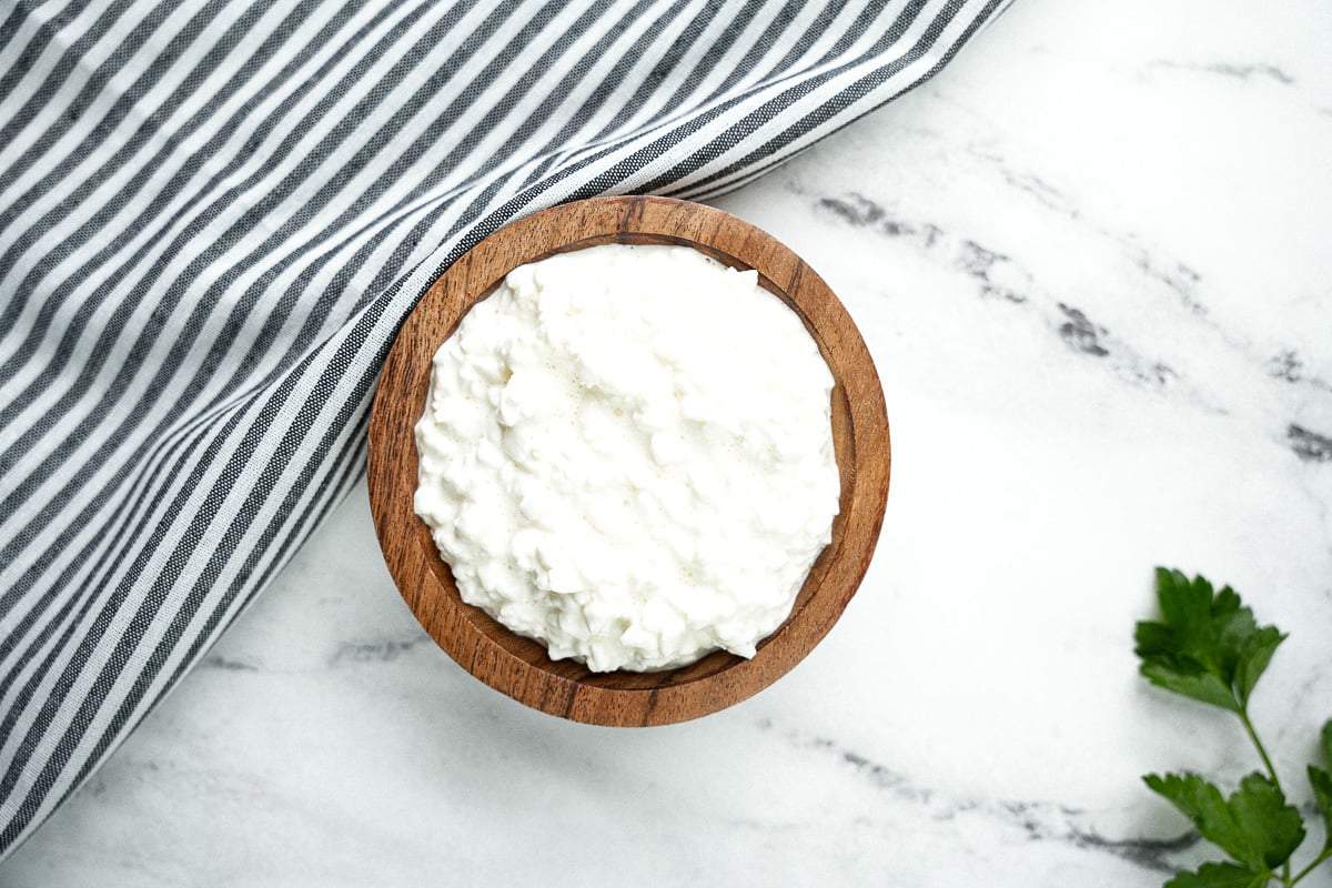 cottage cheese in wooden bowl on countertop